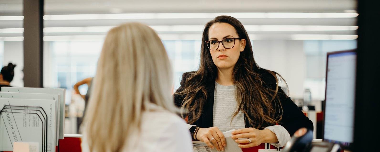 Brown haired woman talking to her coworker