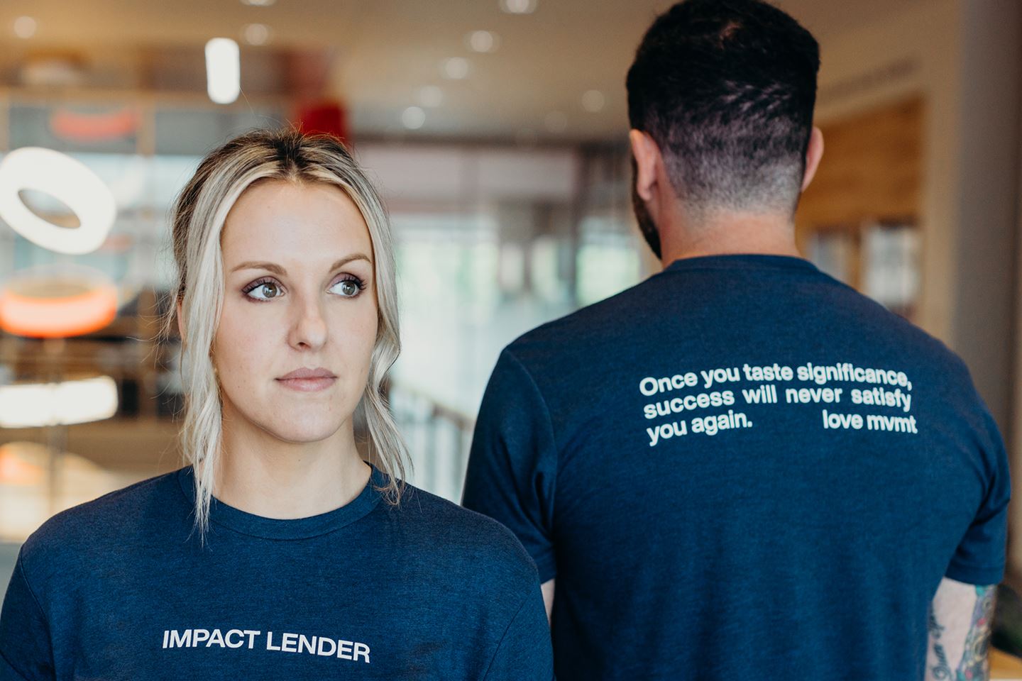 Man and woman model IMPACT Lender t-shirt