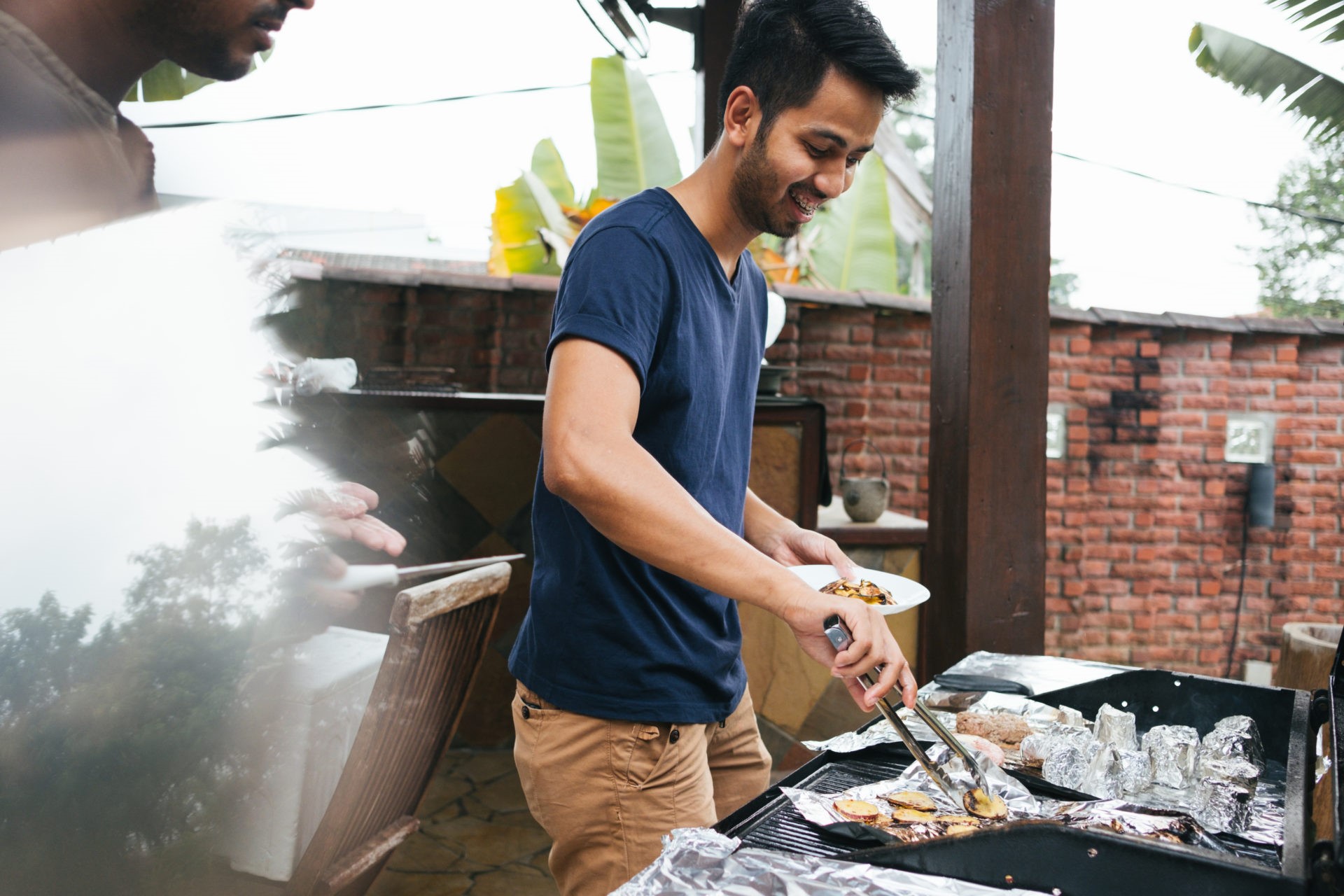 Two Young Men Preparing Barbecue Outdoors