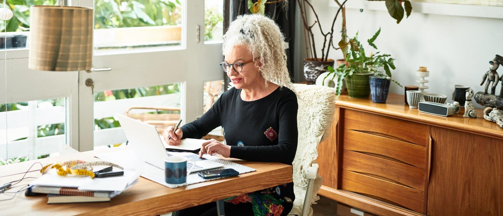 Elder blonde woman working on her laptop