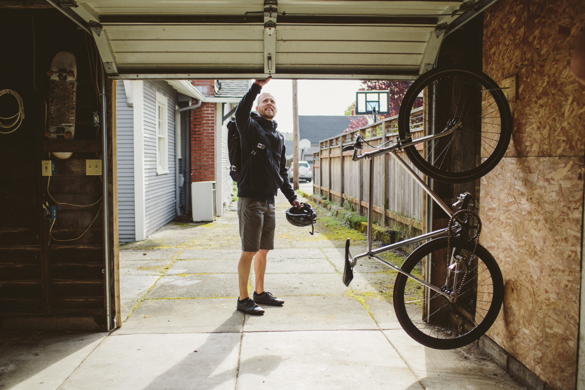 Male commuter with backpack closing garage door