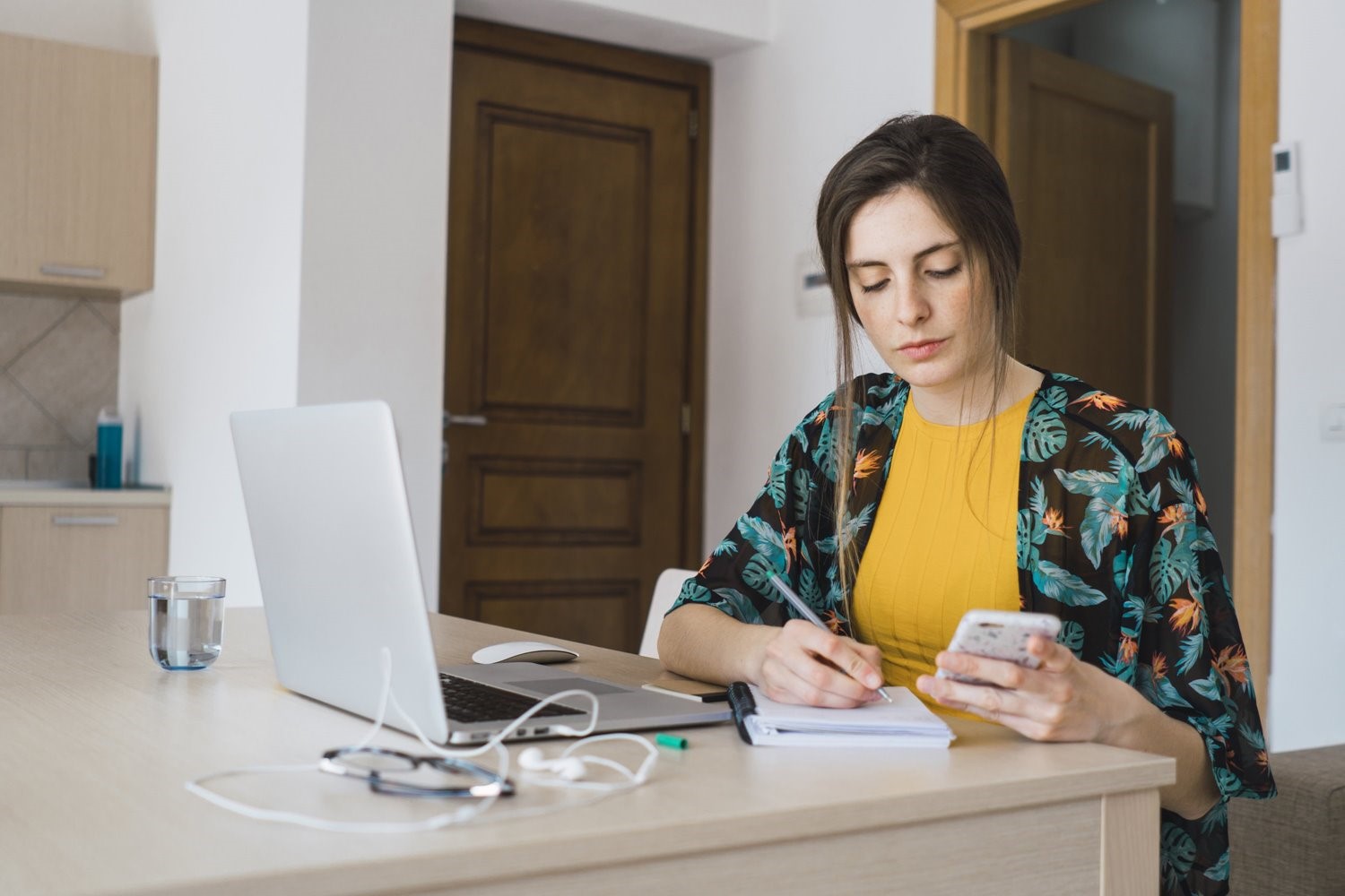 Woman in yellow shirt writing down notes