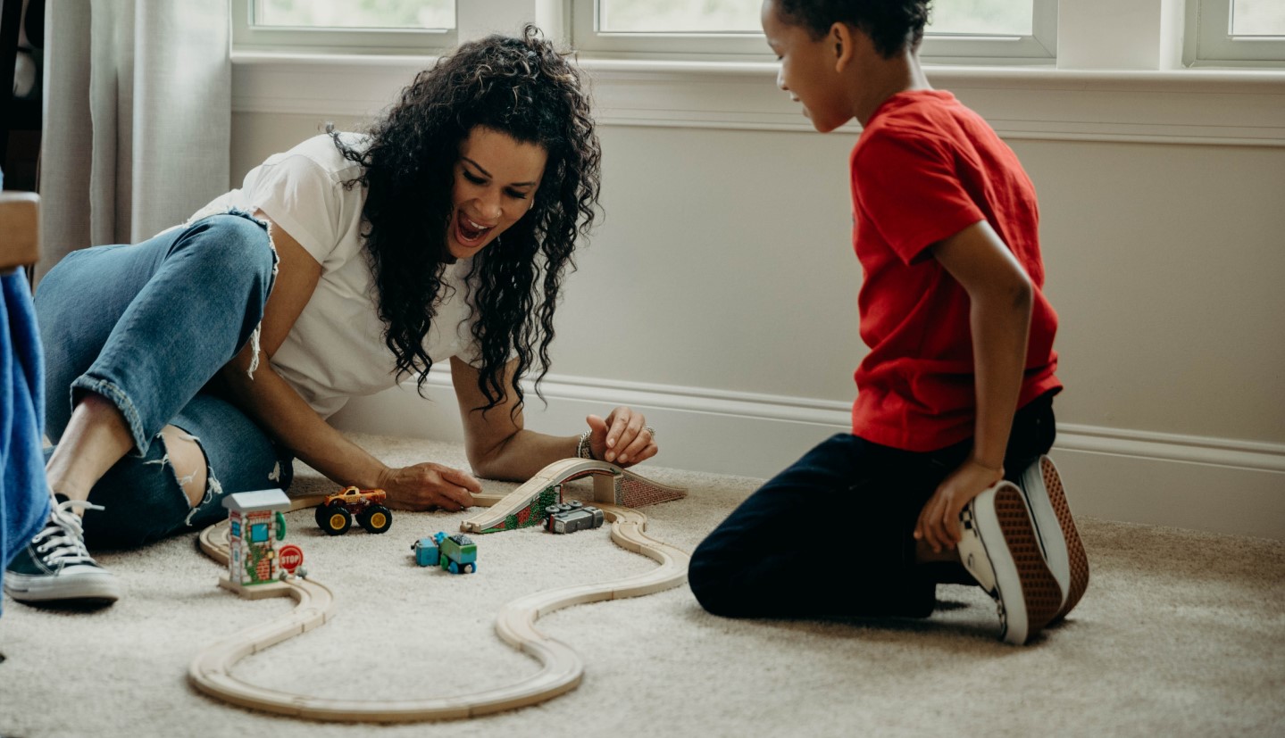 mother and child playing on the floor together inside a home